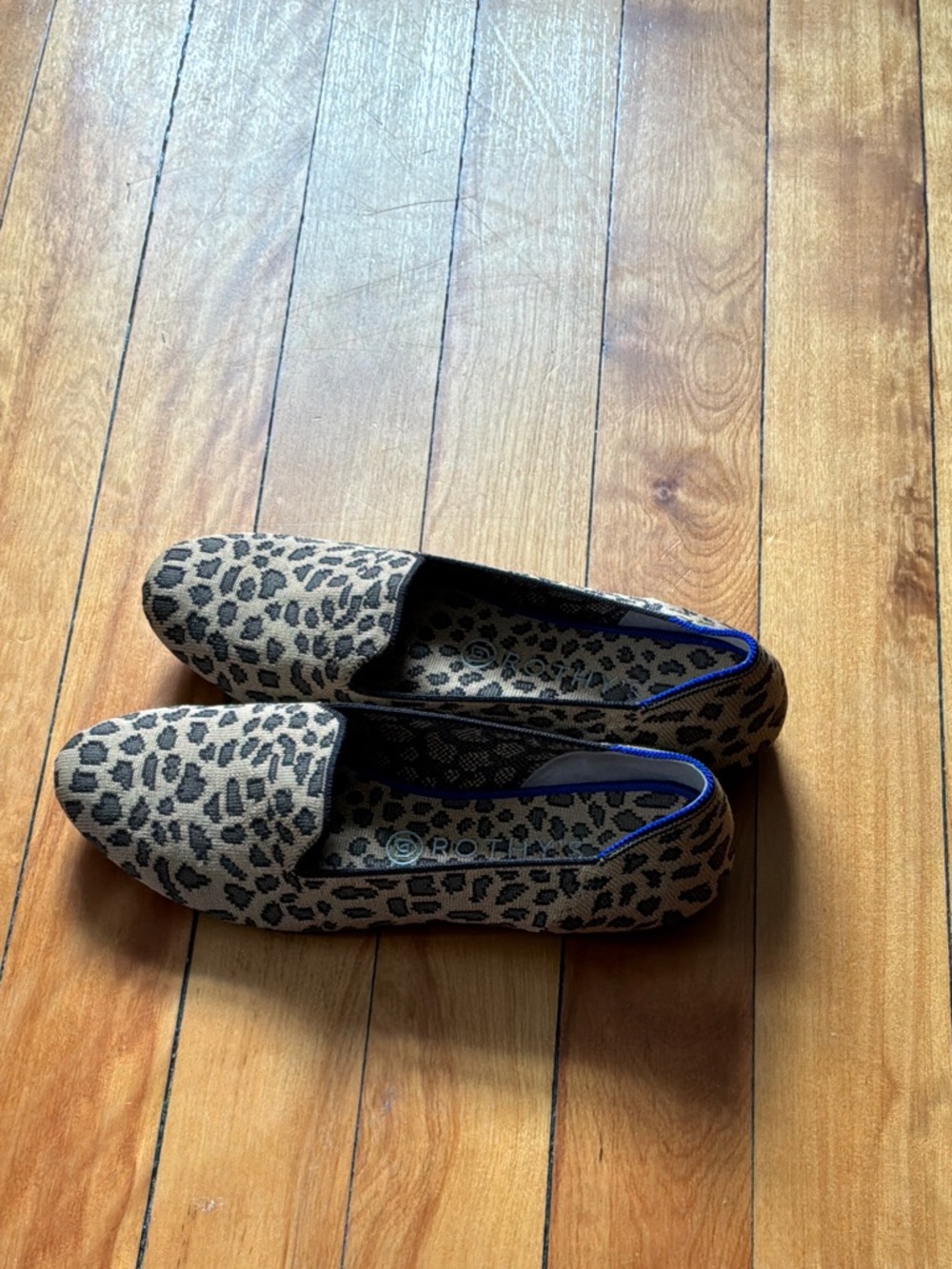 Rothy’s almond toe Leopard print slip-on’s with blue piping.